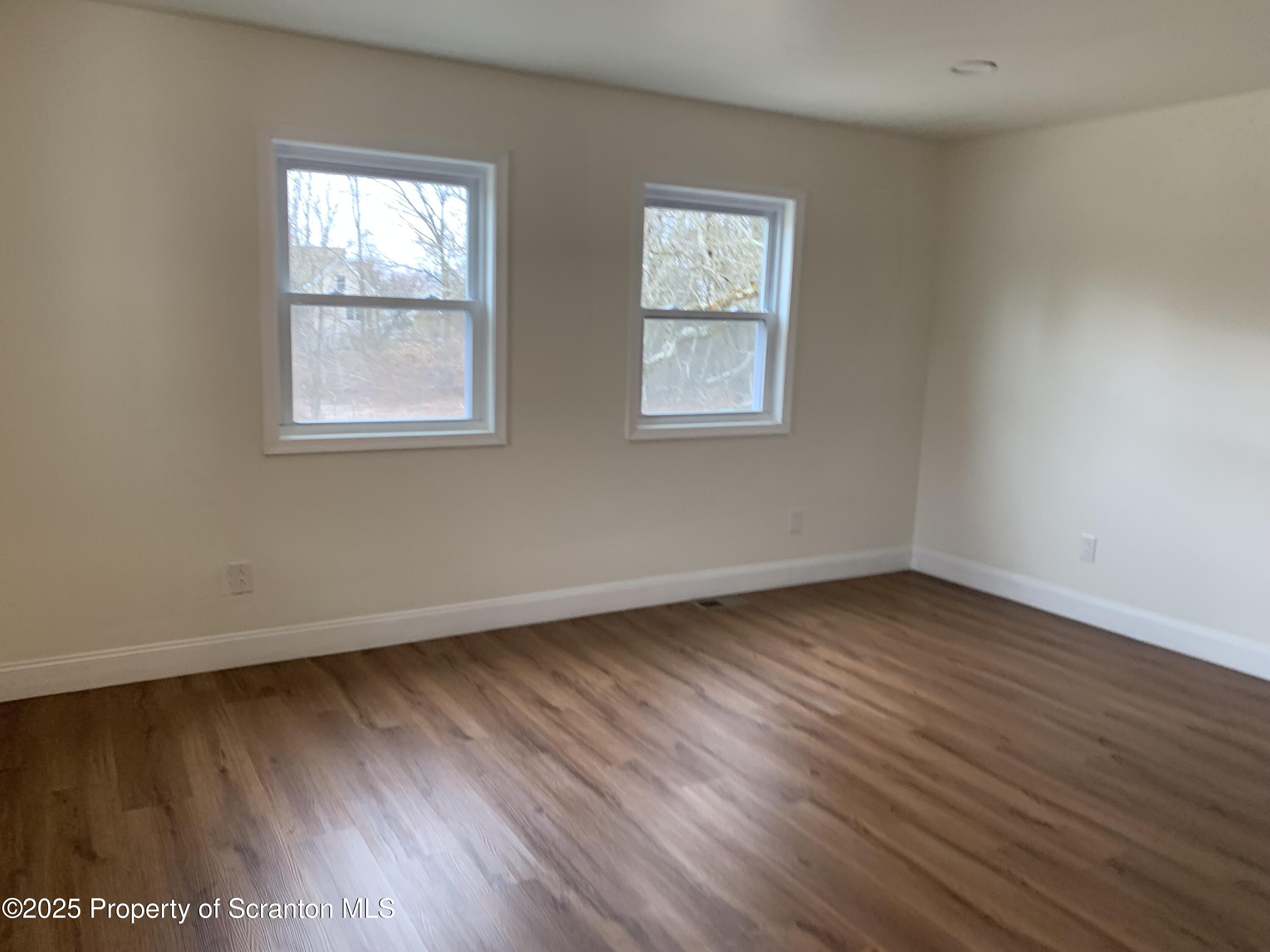 318 Simrell Road Clarks Summit, PA 18411 - Photo 19 of 30 an empty room with wooden floor and windows
