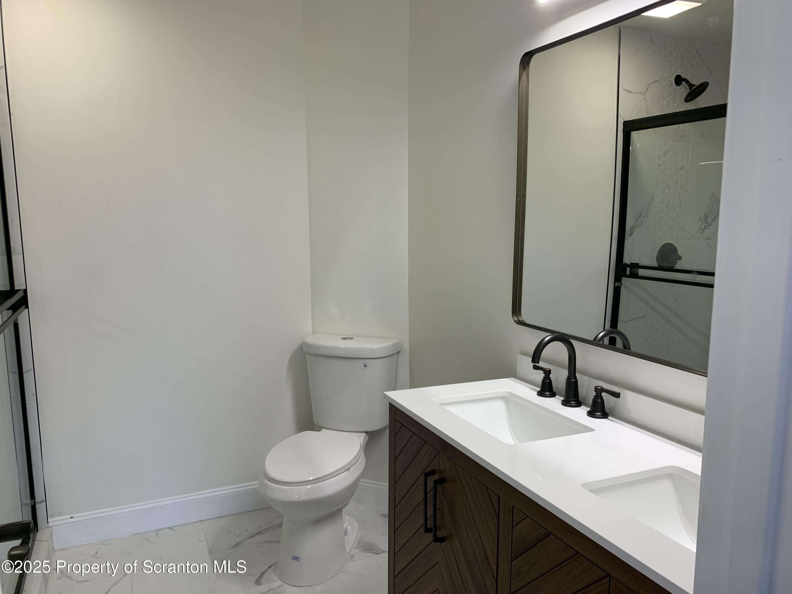 318 Simrell Road Clarks Summit, PA 18411 - Photo 27 of 30 a bathroom with a sink a toilet and mirror