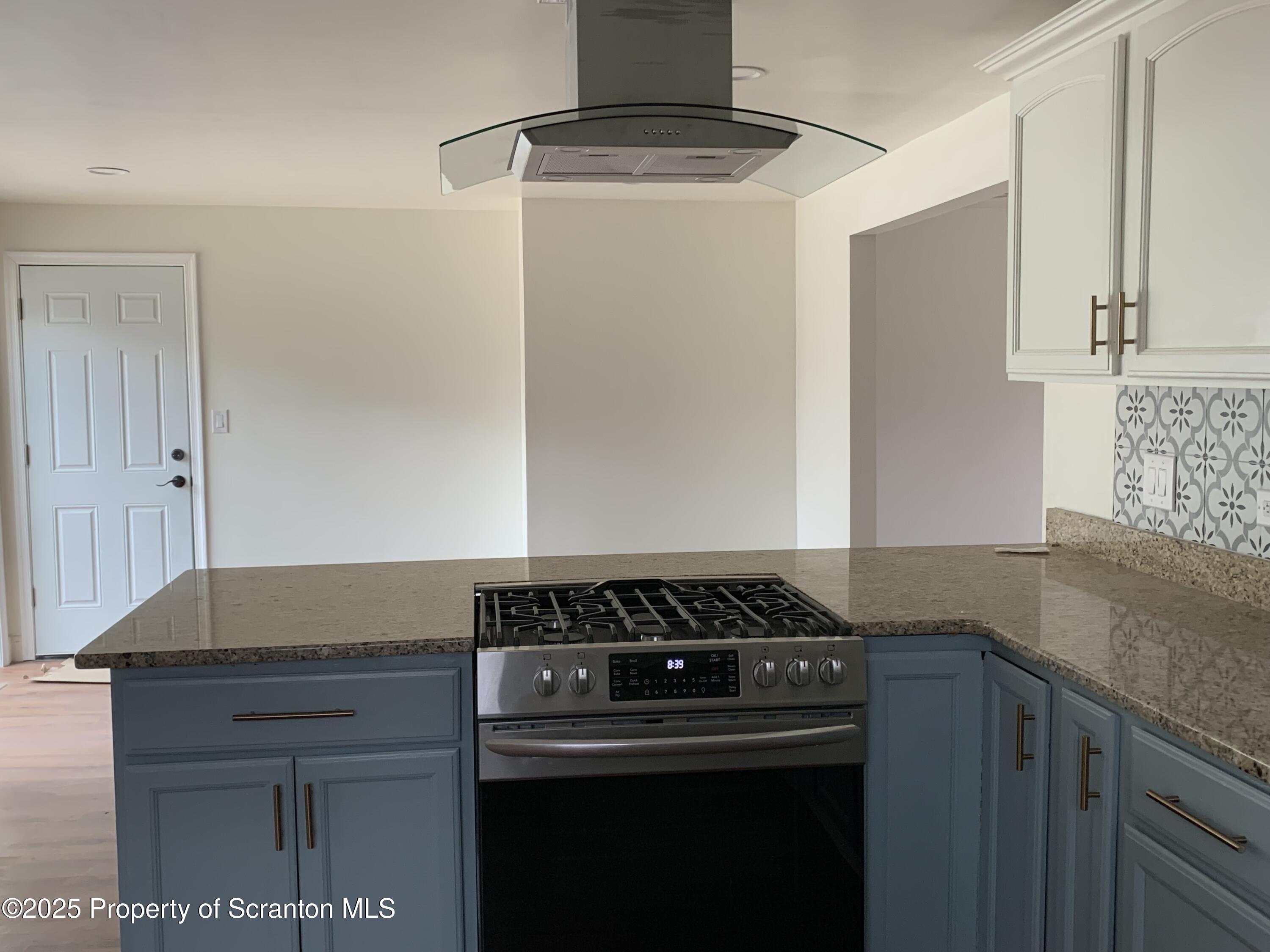 318 Simrell Road Clarks Summit, PA 18411 - Photo 3 of 30 a kitchen with granite countertop a stove and a sink