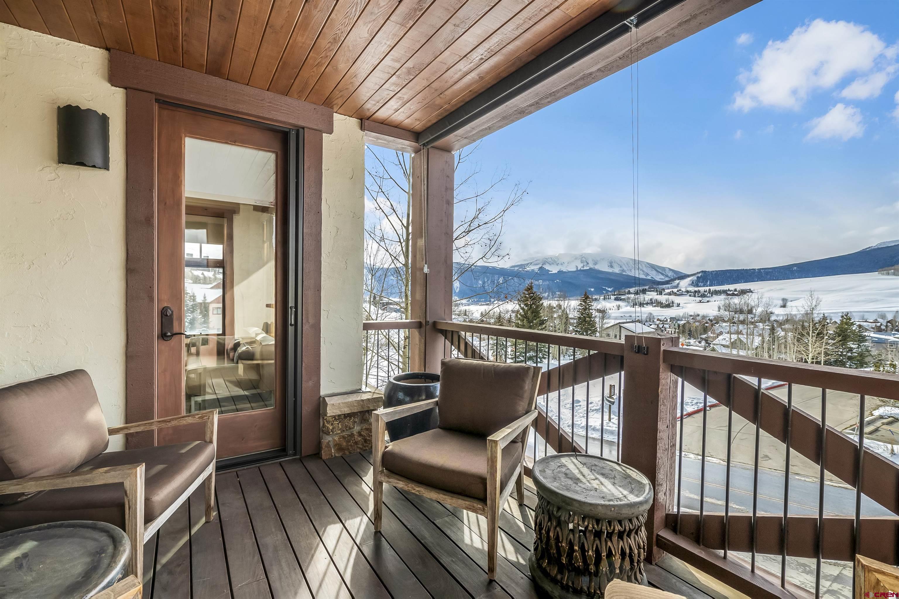 14 Hunter Hill Road, Unit A204 Crested Butte, CO 81225 - Photo 3 of 36 a balcony with wooden floor table and chairs
