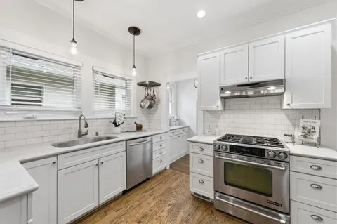 a kitchen with white cabinets and appliances