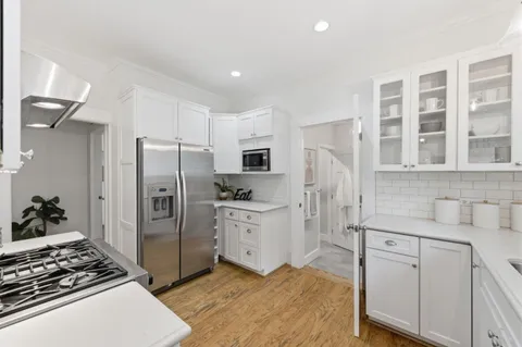 a kitchen with white cabinets and appliances