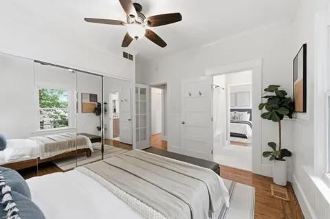 a spacious bedroom with two beds and a potted plant