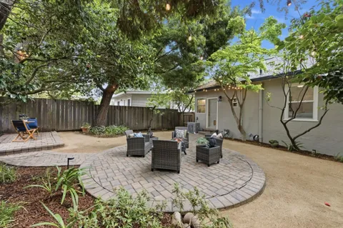 a view of backyard with table and chairs and wooden fence