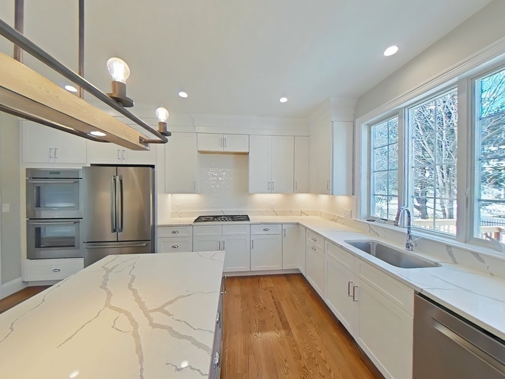 65 Emerson Road Needham, MA 02492 - Photo 4 of 37 a large kitchen with stainless steel appliances kitchen island granite countertop a sink and cabinets