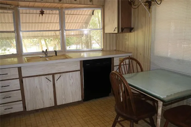 a kitchen with a table chairs and a window