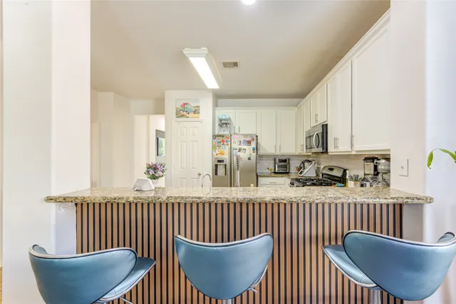 a living room with furniture and a dining table with kitchen view