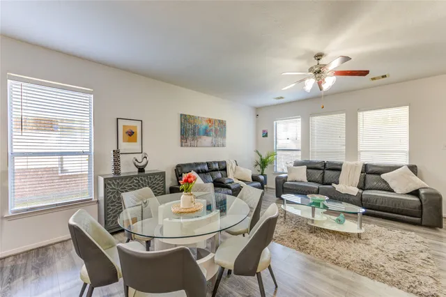 a living room with furniture a flat screen tv and a chandelier
