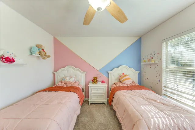 a bedroom with two beds and a window