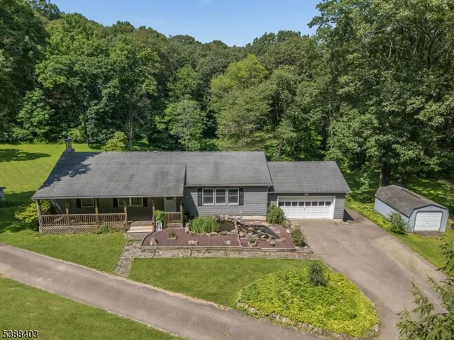 an aerial view of a house with swimming pool and a yard