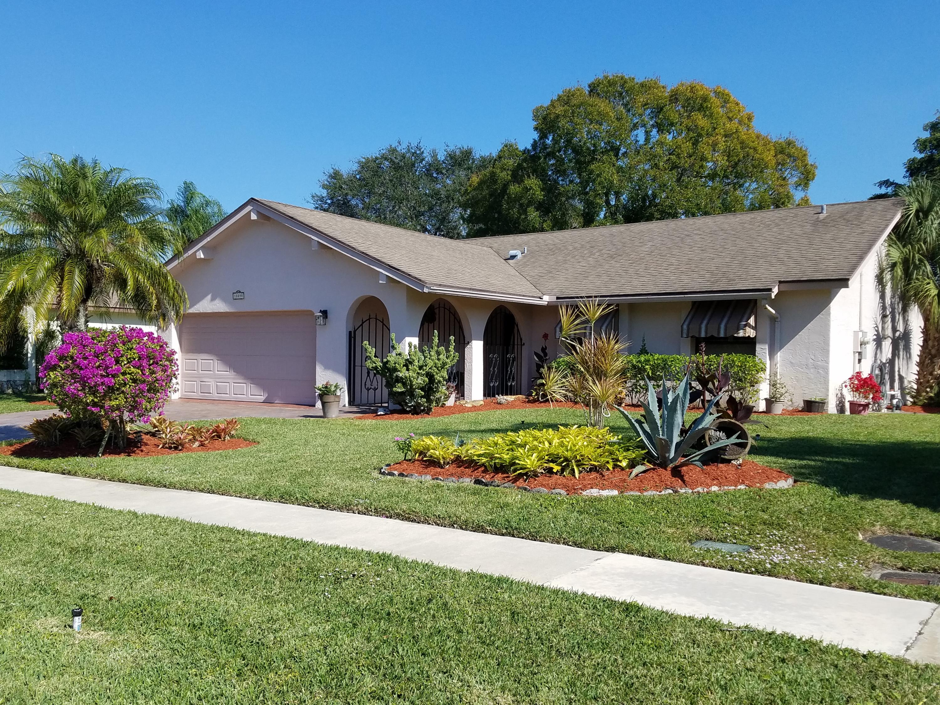 18090 104th Terrace South Boca Raton, FL 33498 - Photo 1 of 25 a front view of a house with a garden and plants