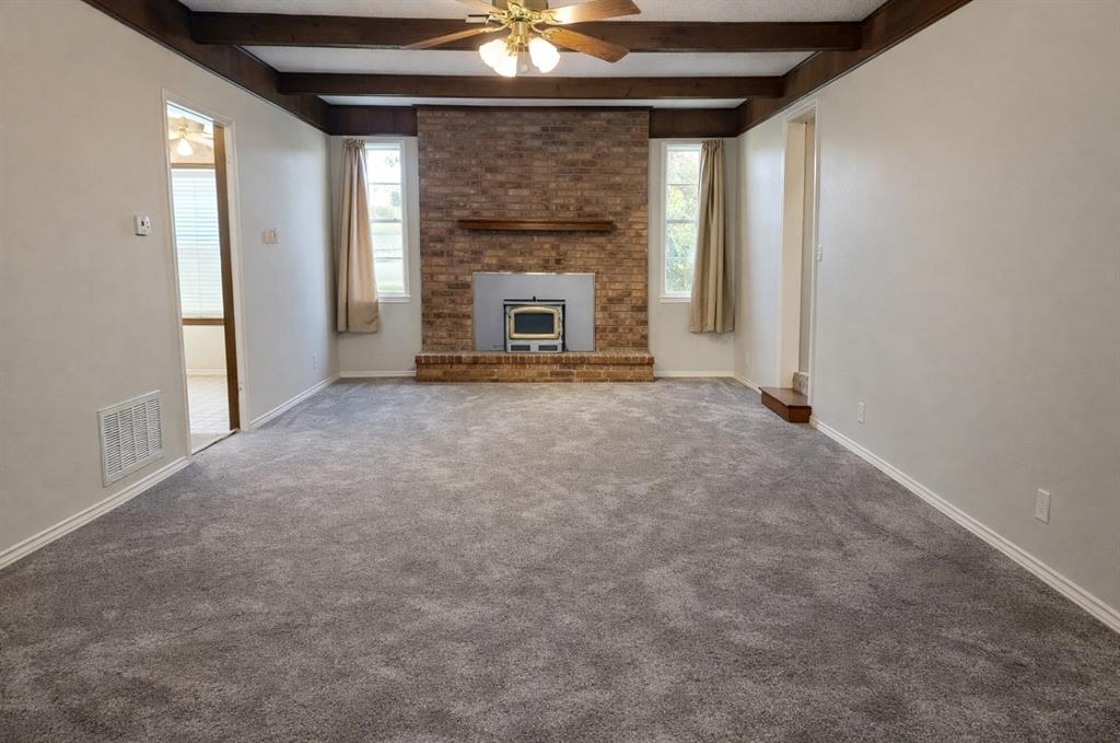 2302 Shiloh Street Denison, TX 75020 - Photo 5 of 16 an empty room with windows and fireplace
