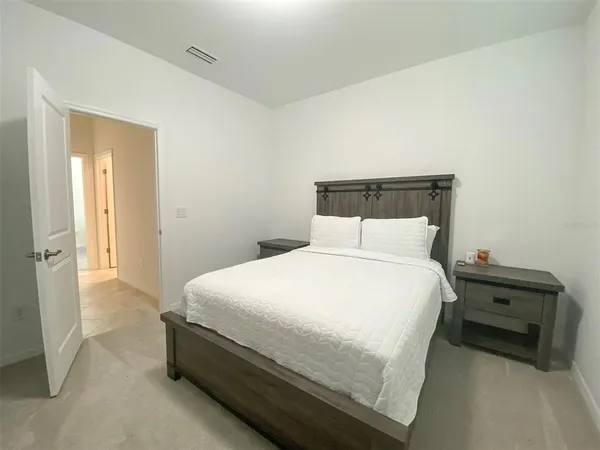 a bedroom with a bed and a night stand