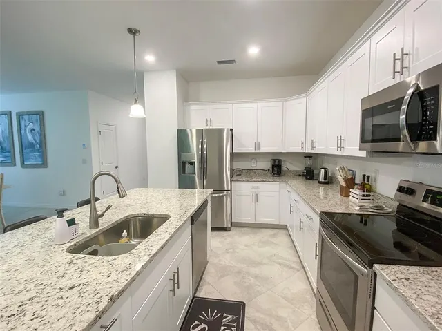 a kitchen with a sink stove top oven and refrigerator