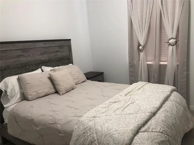 a bedroom with a bed and a window