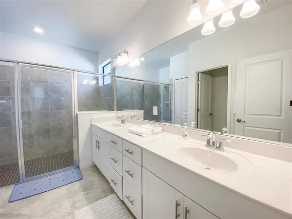 a bathroom with a double vanity sink mirror and shower