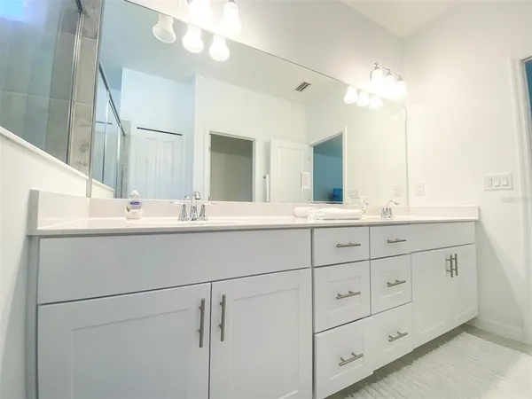 a bathroom with a double vanity sink and a mirror
