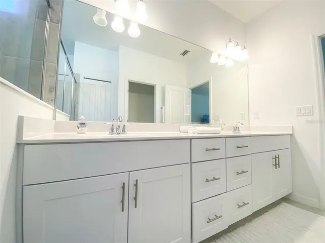 a bathroom with a double vanity sink and a mirror