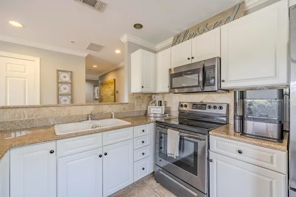 a kitchen with cabinets stainless steel appliances a sink and a stove