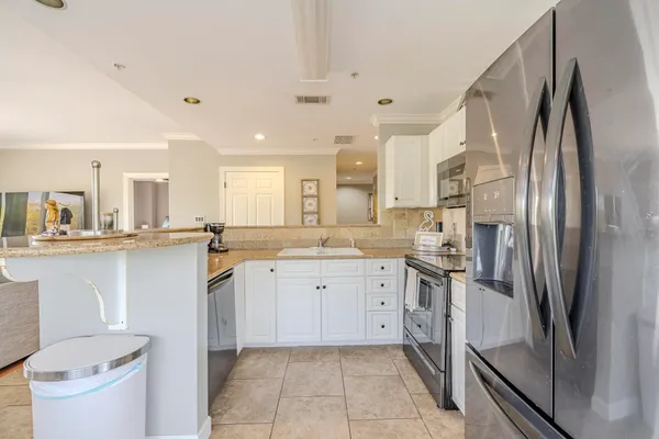 a kitchen with a refrigerator sink and cabinets