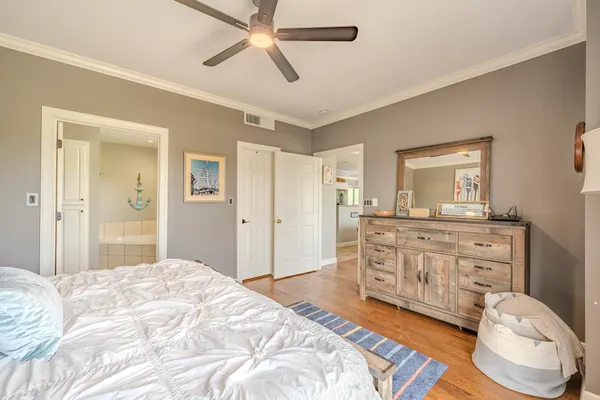 a spacious bedroom with a bed and a dresser