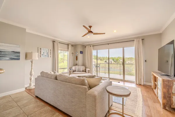 a living room with furniture a flat screen tv and a large window