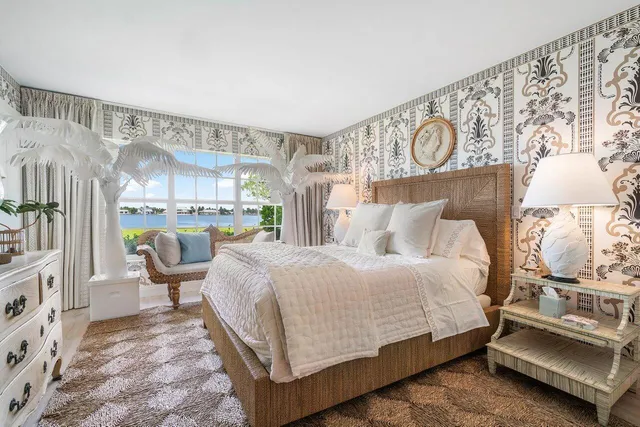 a bedroom with a bed a mirror and lamp on desk