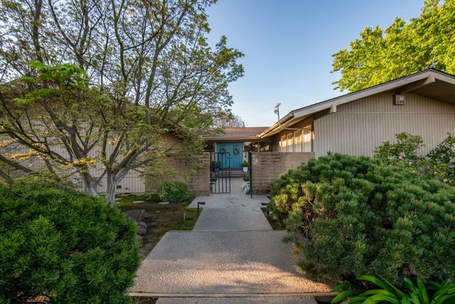 front view of a house with a yard and potted plants