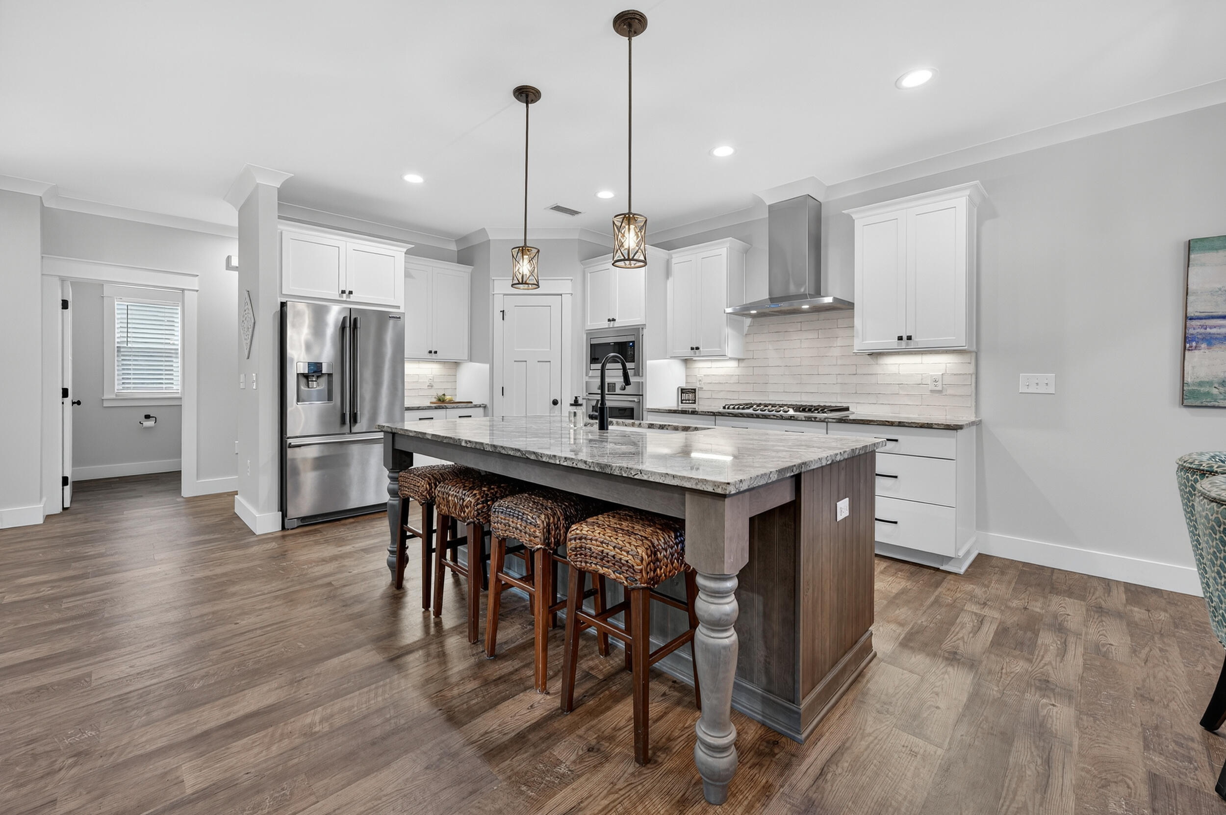 768 Long Road DeFuniak Springs, FL 32433 - Photo 14 of 106 a kitchen with stainless steel appliances granite countertop a table chairs wooden floors and a large window