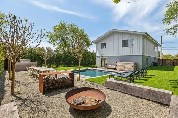 a view of backyard with swimming pool and outdoor seating