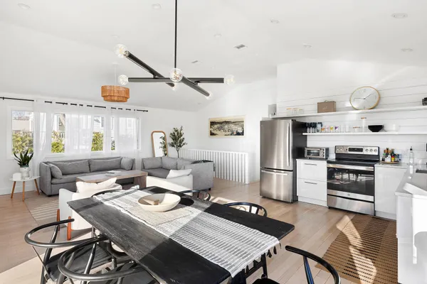 a kitchen with a table chairs a stove and a window