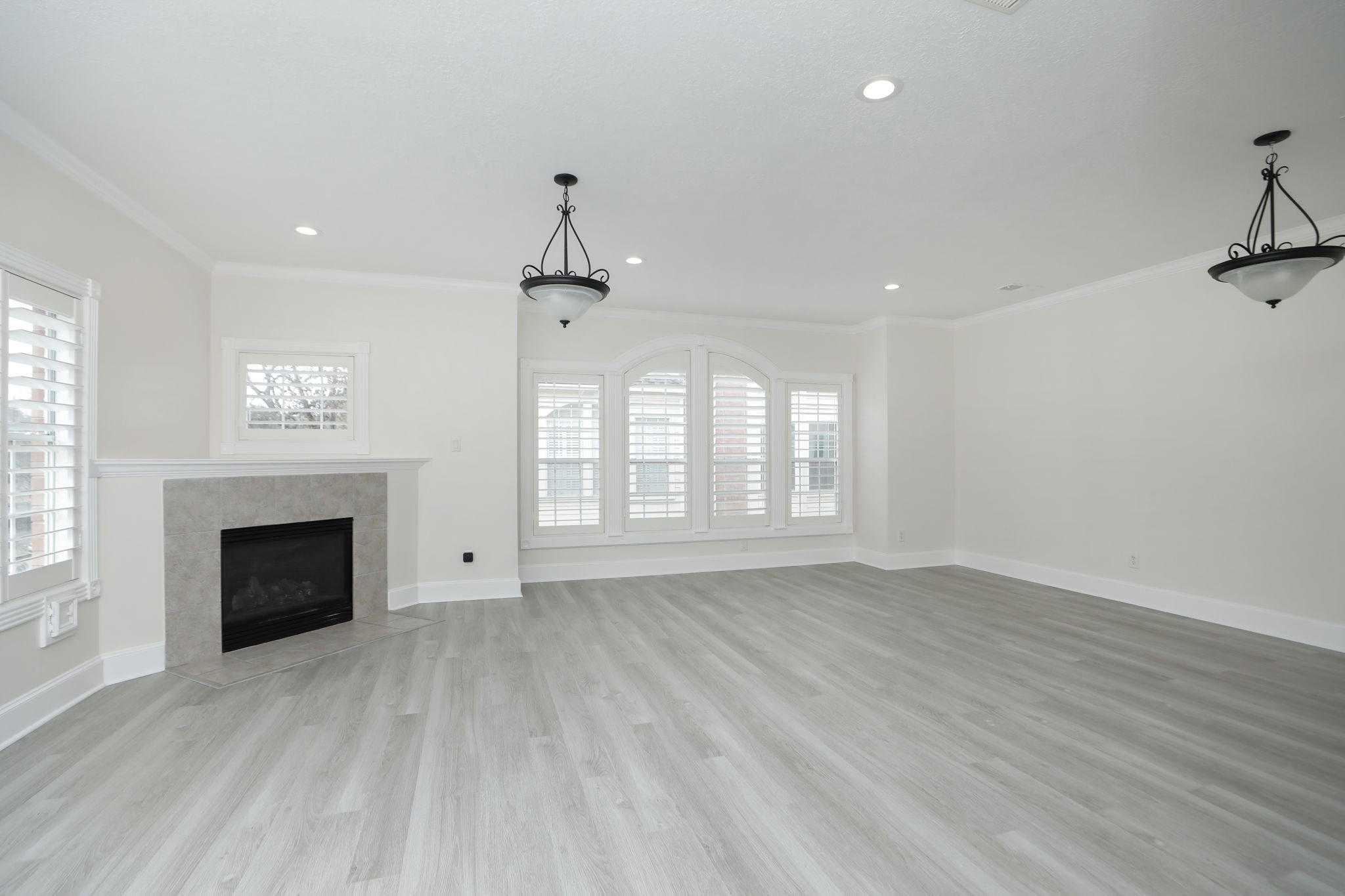1893 Ewing Street Houston, TX 77004 - Photo 12 of 39 an empty room with windows fireplace and wooden floor