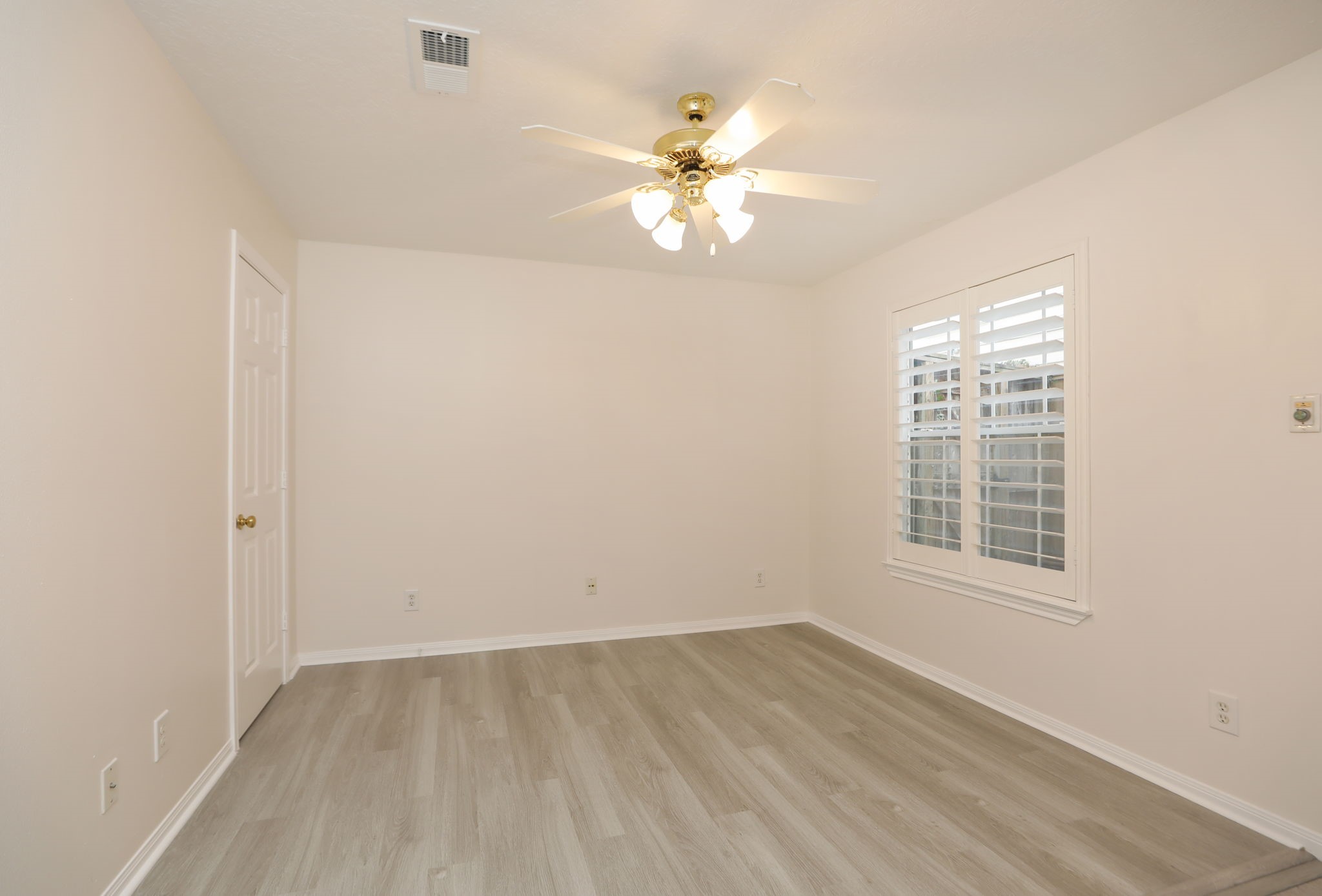 1893 Ewing Street Houston, TX 77004 - Photo 8 of 39 an empty room with wooden floor fan and windows