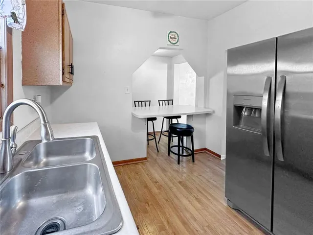 a kitchen with granite countertop a refrigerator and a sink