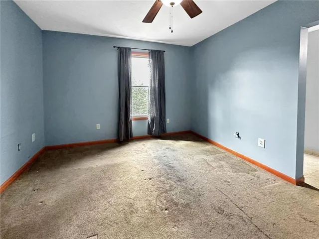 an empty room with closet and a chandelier fan