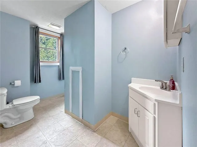 a bathroom with a sink toilet and window