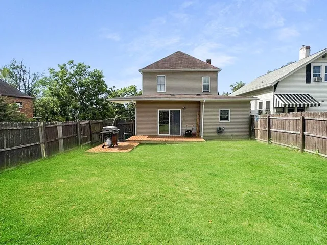 a front view of a house with backyard and garden