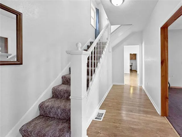 a view of entryway and hall with wooden floor