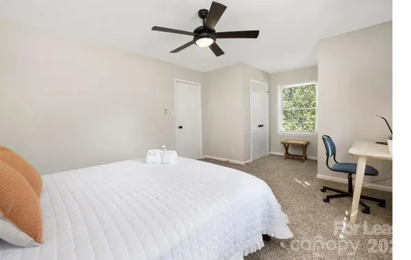 a bedroom with a bed a chair and a chandelier