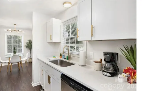 a kitchen with a sink dishwasher a stove and a refrigerator with wooden floor