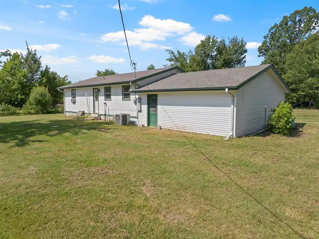 a front view of a house with a yard and trees