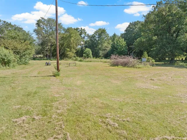 a picture of a yard with table and chairs and wooden fence