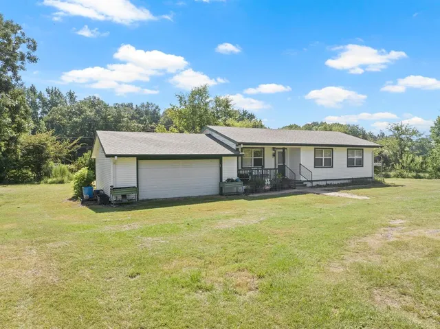 a view of a house with pool and a yard
