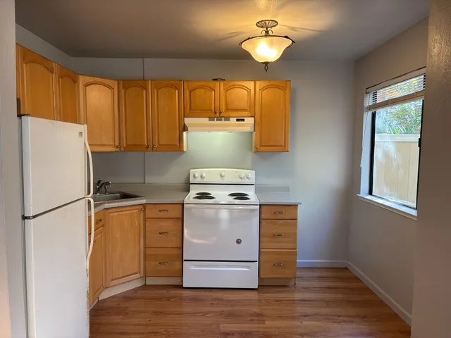 a kitchen with a stove a refrigerator and a window