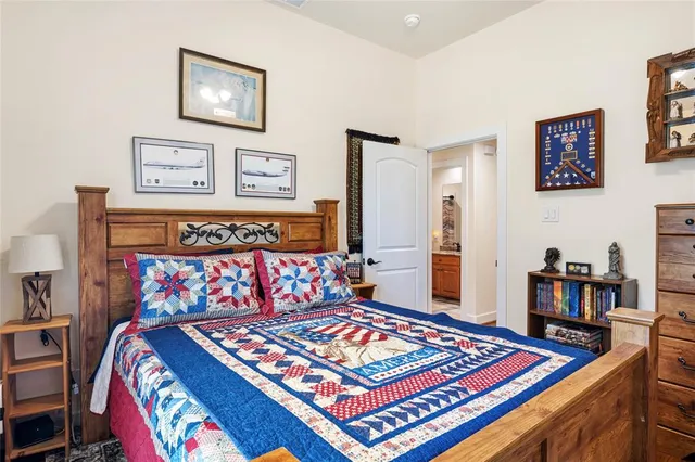 a bedroom with a bed and dresser next to a window