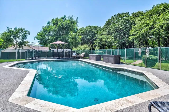 a view of a swimming pool with a patio and a yard