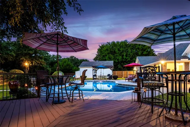a view of a patio with table and chairs under an umbrella with wooden floor