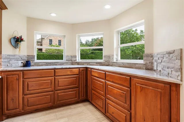 a open kitchen with granite countertop a sink and dishwasher with wooden cabinets