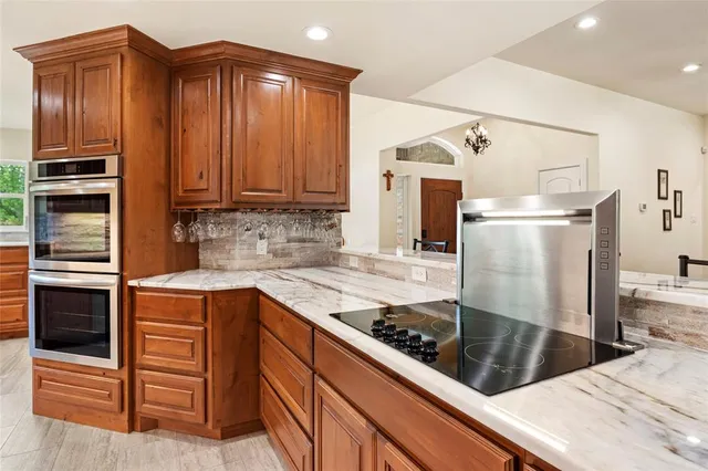 a kitchen with stainless steel appliances granite countertop a stove a sink and a microwave