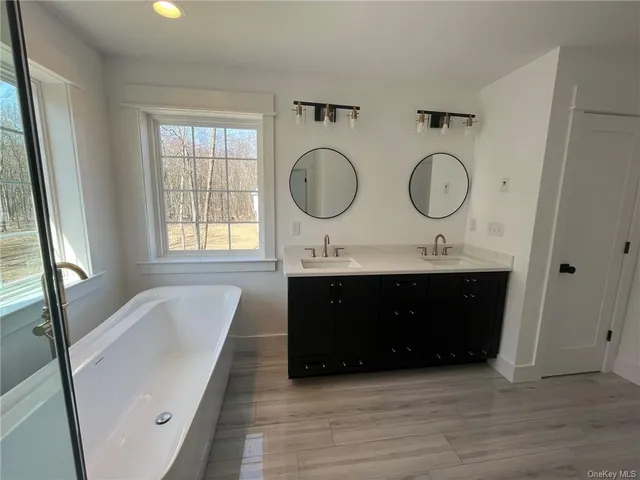 a bathroom with a double vanity sink a mirror and a window